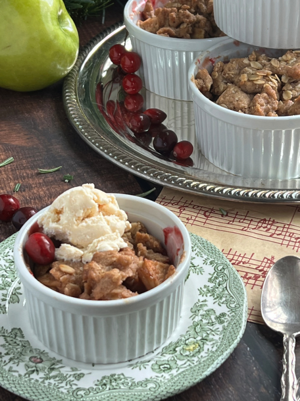 apple cranberry crisp white ramekin on green and white plate.