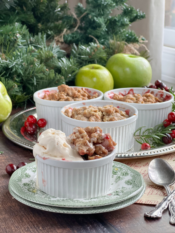 cranberry apple crisp in ramekins with ice cream.