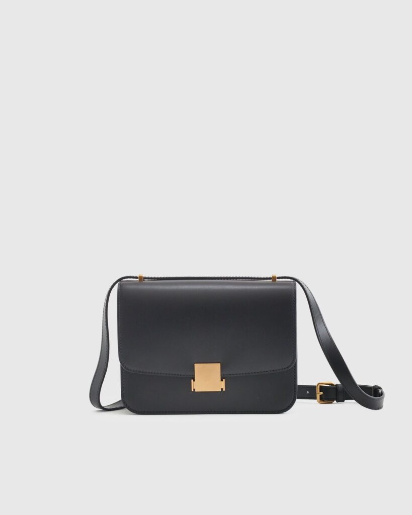 Quince black leather bag with gold hardware. 