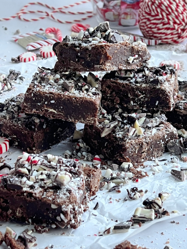 Peppermint Bark Brownies stacked with scattered candy and red and white twine.