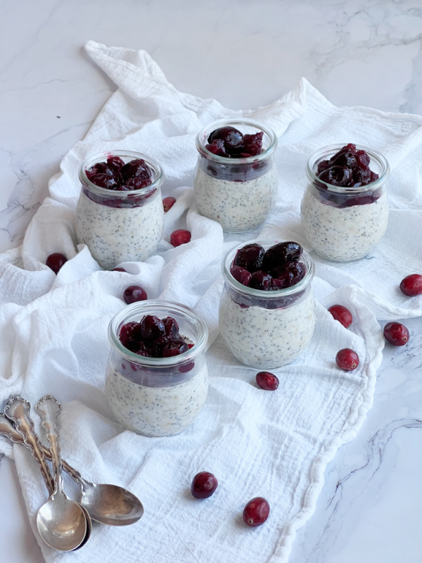 Wek jars of overnight oats and cranberries.