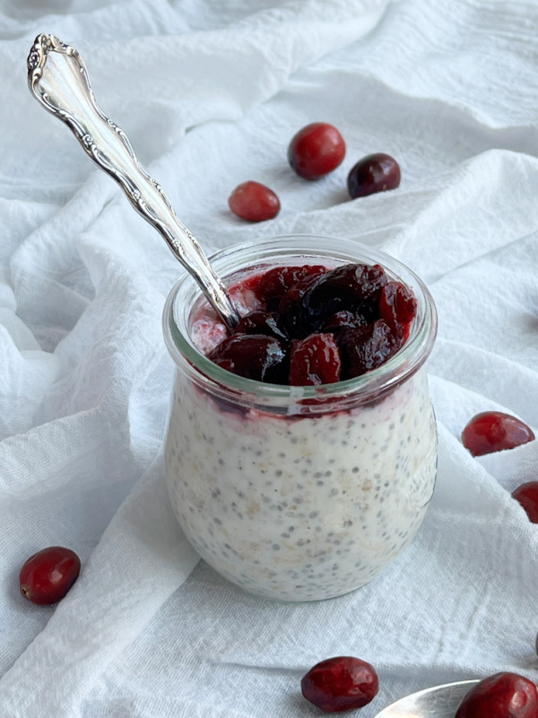 overnight oats and berries with a spoon.