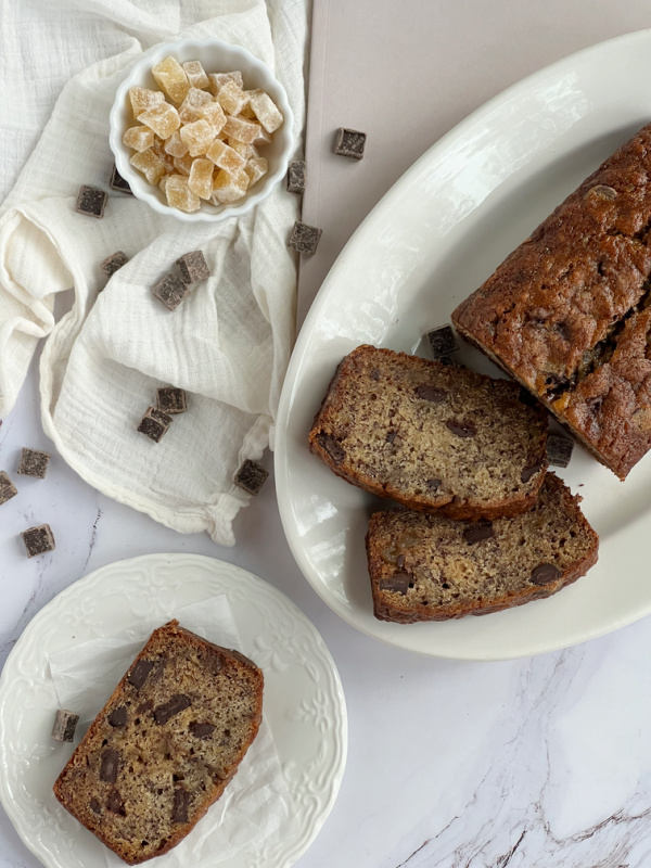 Crystallized Ginger Chocolate Banana Bread sliced on a plate and a platter.