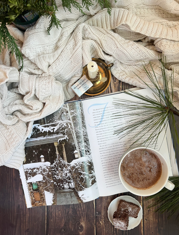 Winter flatlay with book and cup of hot chocolate.