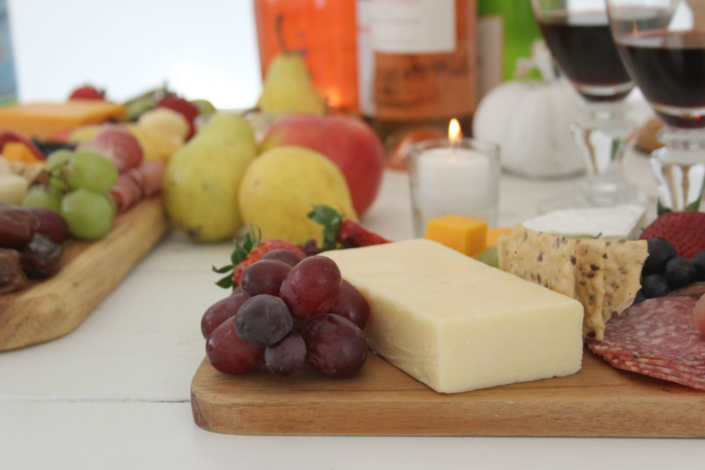 Cheese platters with fruit and candlelight on a white farmhouse table by Hello Lovely Studio