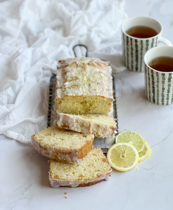 sliced triple citrus bread with 2 green and white cups of tea.