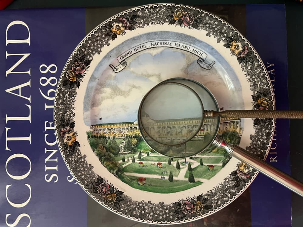 Book with a transfer ware plate and two magnifying glasses.