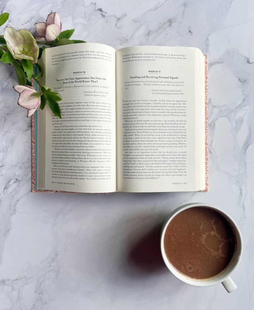 midlife self discovery — morning ritual with book and hot chocolate reflecting on who you have always been.