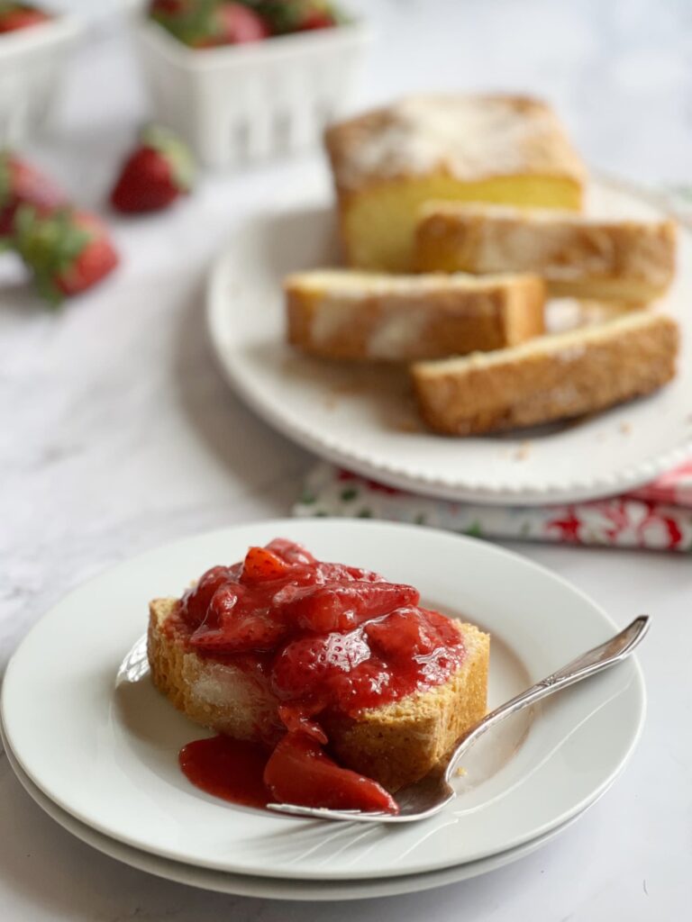 Slice of brown butter pound cake topped with strawberry compote