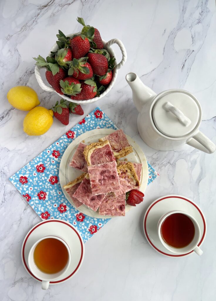 Strawberry cheesecake swirl bars a pot of tea and two cups