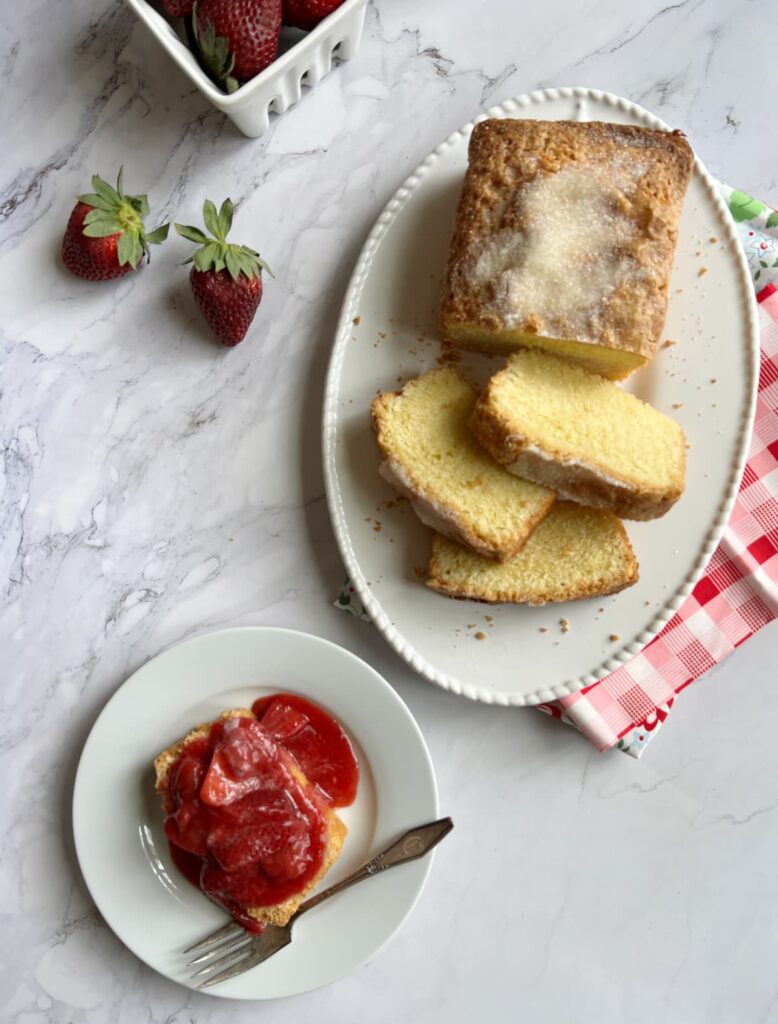 sliced pound cake and a piece on a plate with strawberries