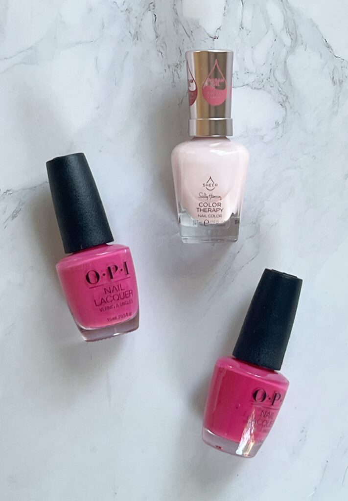spring nail colors for women — pale pink and bright OPI nail polish flat lay
