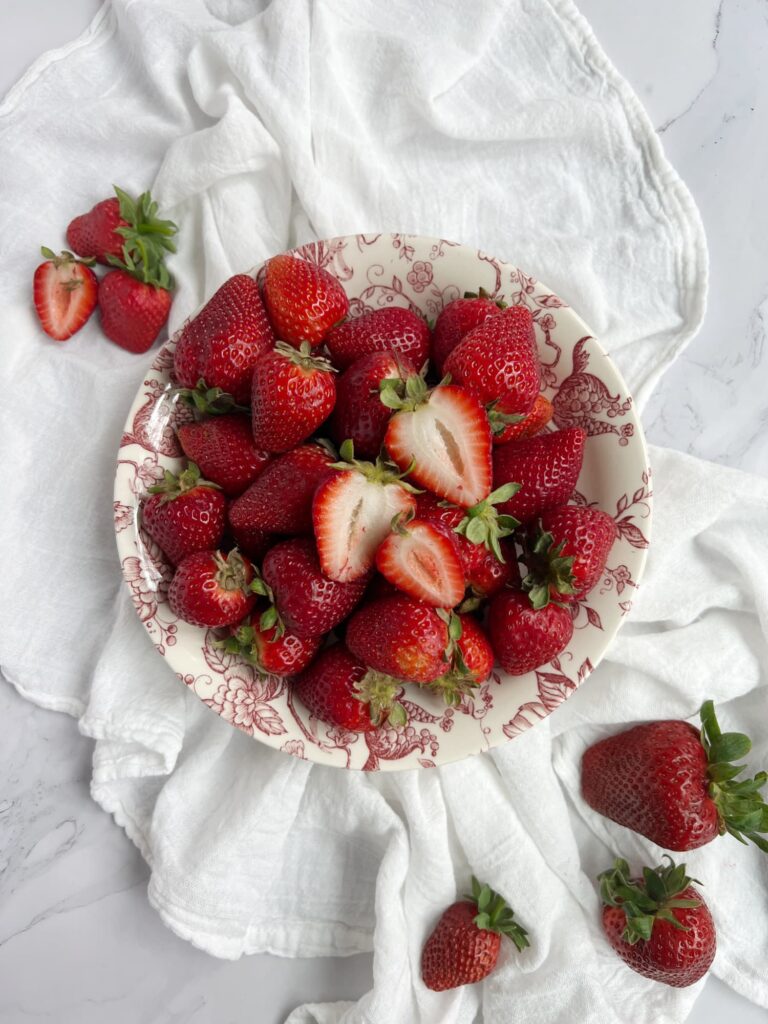 red and white transfer ware bowl of fresh strawberries