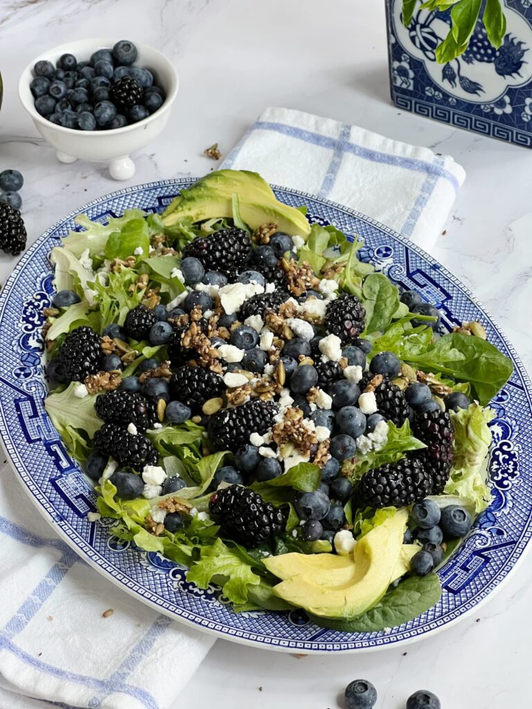 Blueberry Blackberry salad on a platter with a white bowl of blueberries
