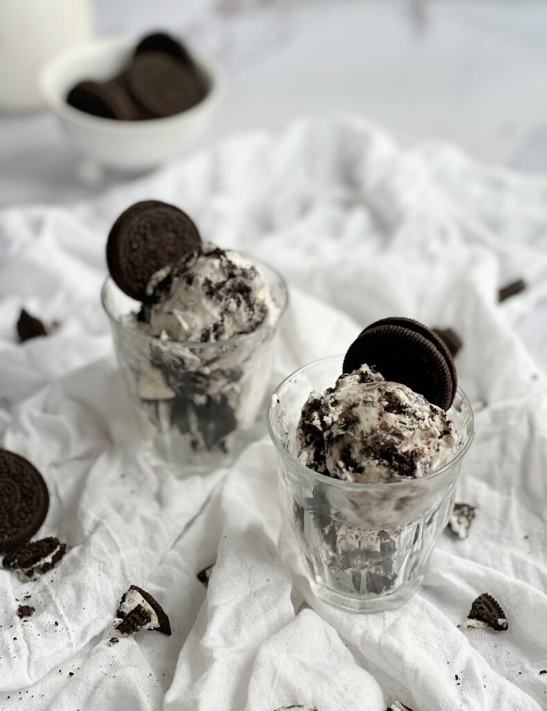 No churn cookies and cream ice cream in a glass with Oreo chunks.