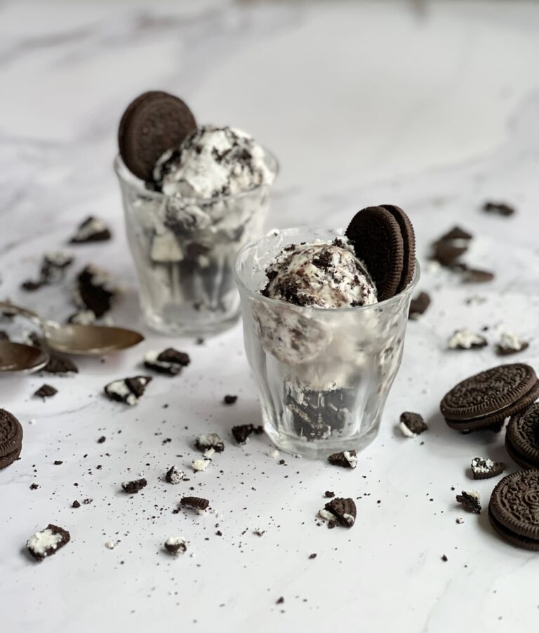 No churn cookies and cream ice cream in glasses with Oreos scattered about