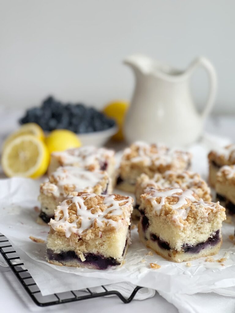 slices of moist blueberry coffee cake with pecan streusel on a wire rack