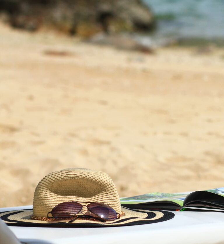 Book, sunglasses, hat at the beach
