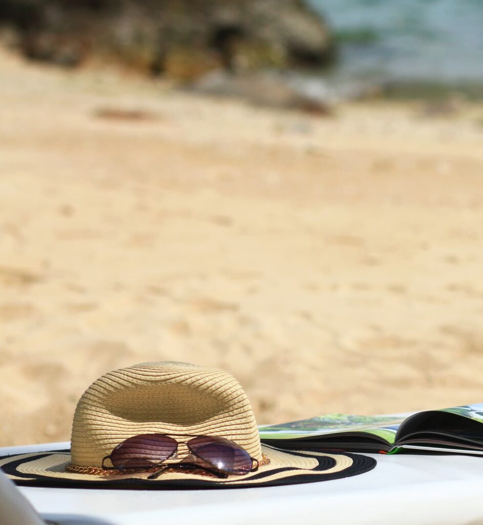 Book, sunglasses, hat at the beach