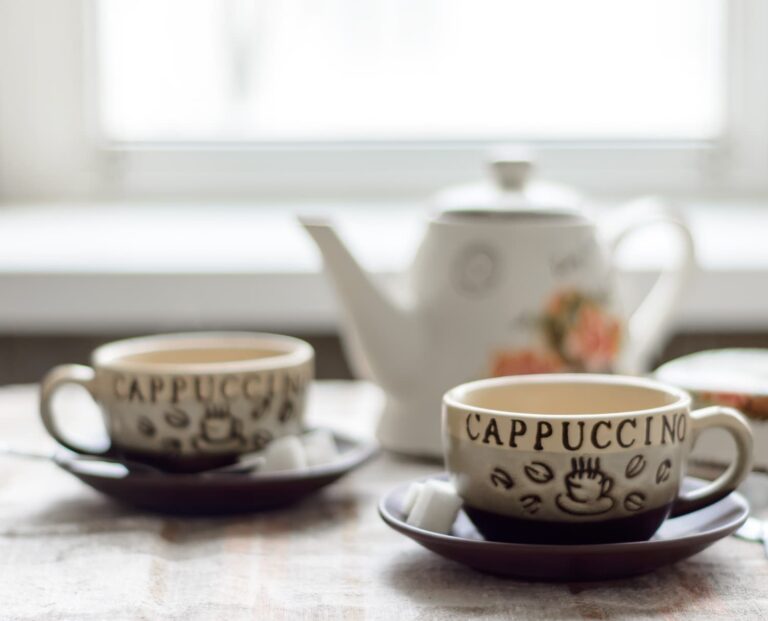 two cups of tea and a teapot on a table in warm morning light