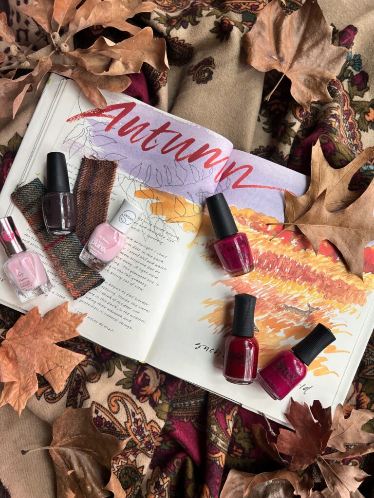 Autumn Nail Colors 6 bottles laying on a book with fall leaves