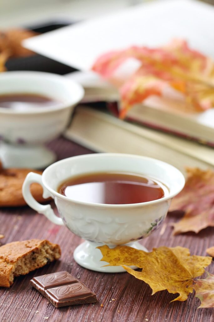 reading books with cup of tea by window autumn leaves
