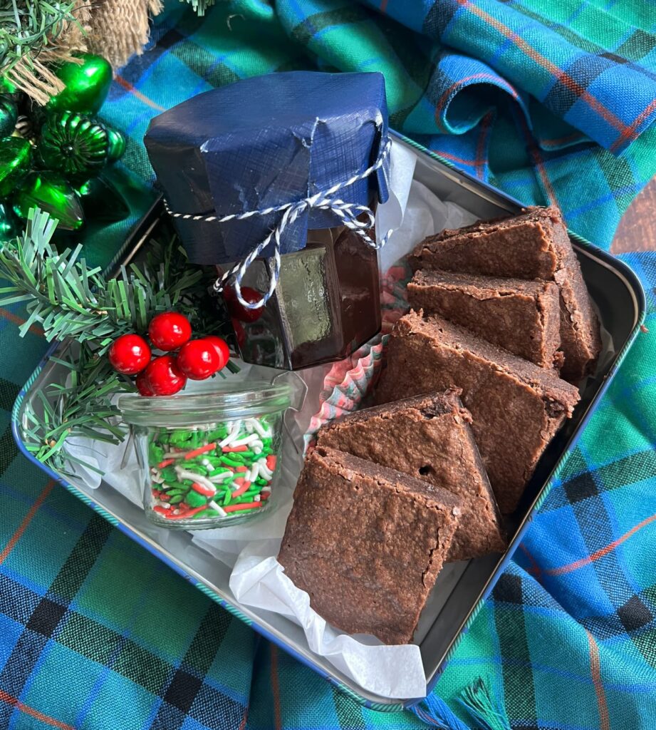 rich glossy salted dark chocolate hot fudge sauce and homemade dark chocolate brownines in a holiday tin 