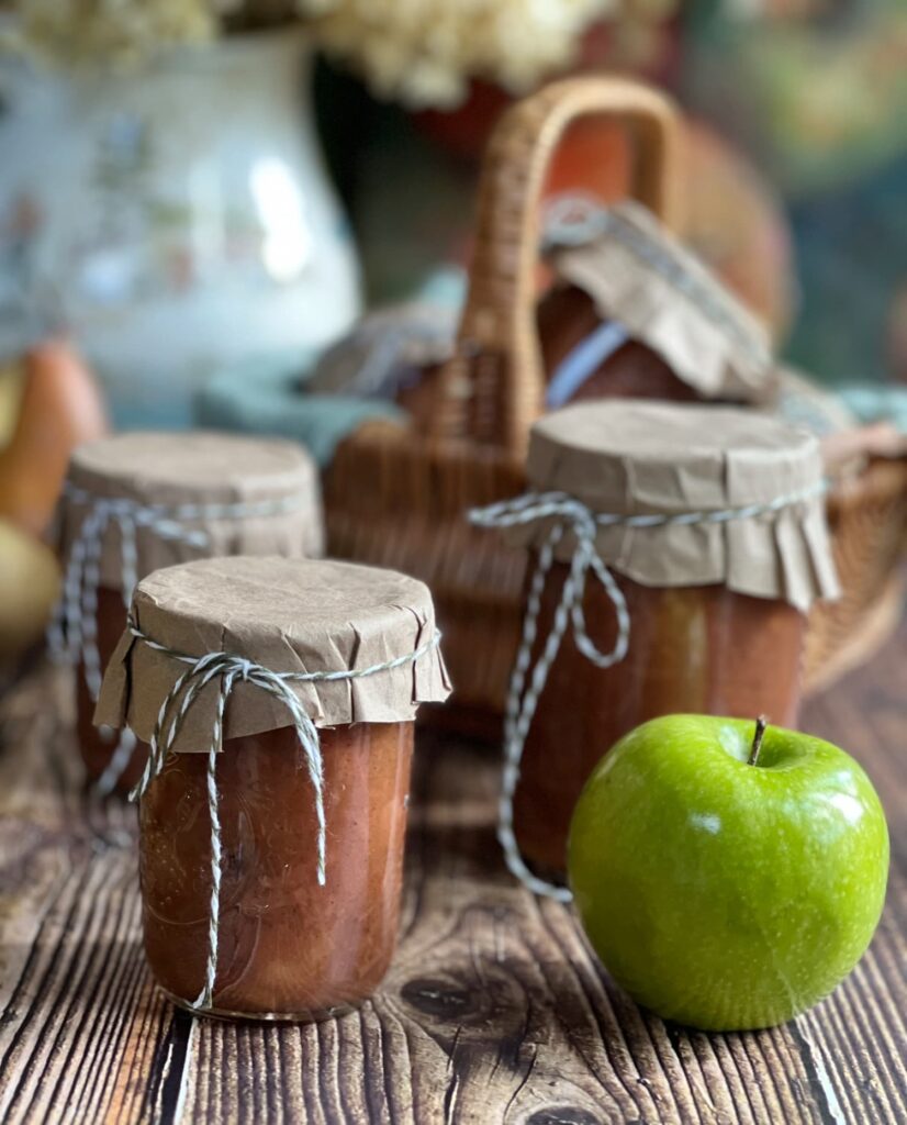 apple pear chutney in jars with a green apple