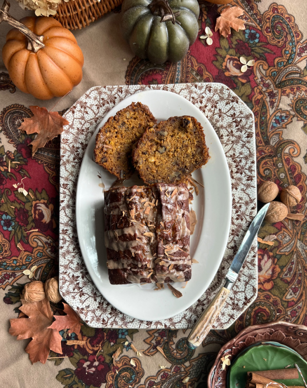 fall flatlay with pumpkin bread and nuts and pumpkins.